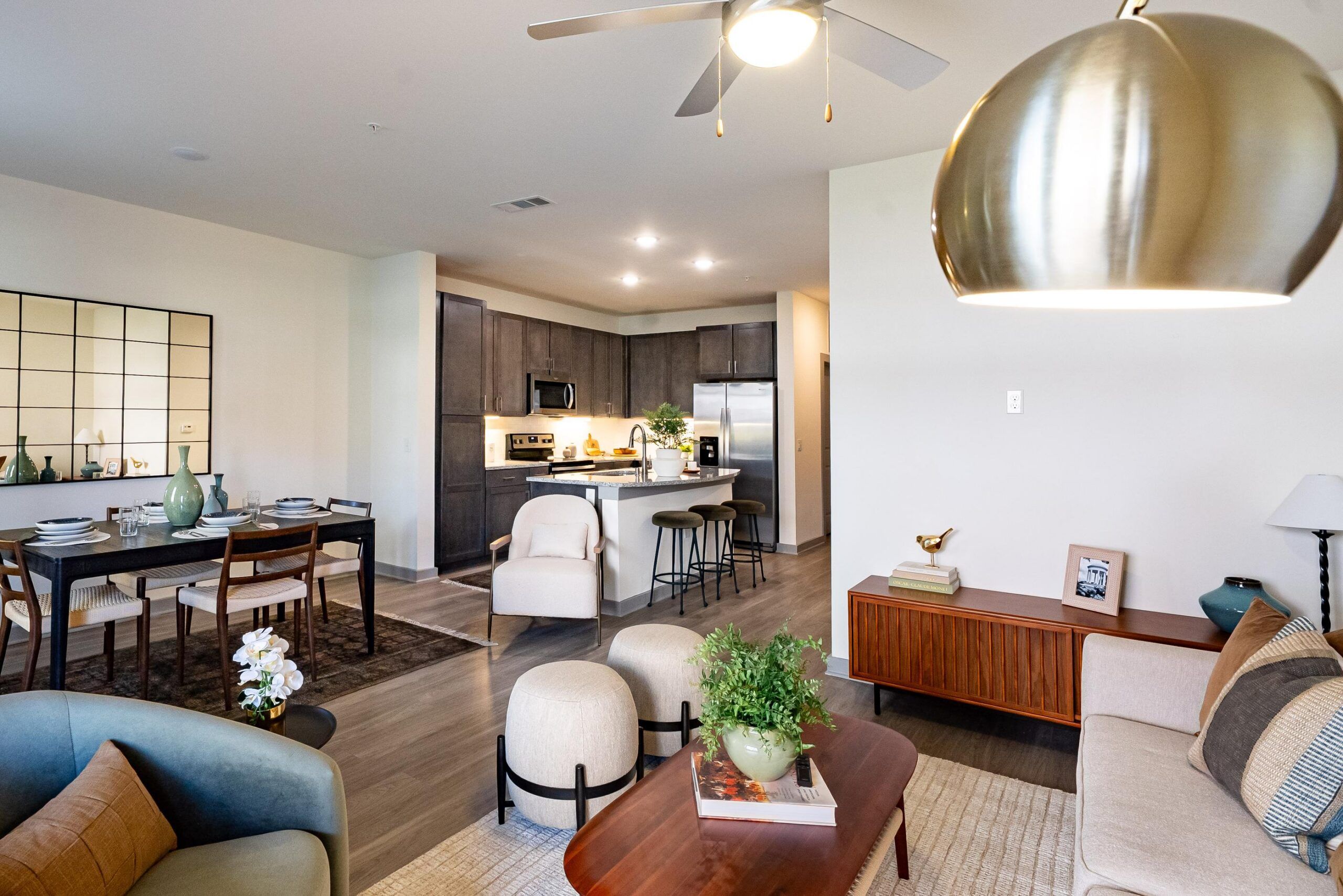 Modern open-concept living and dining area with kitchen, neutral decor, and stylish furnishings.